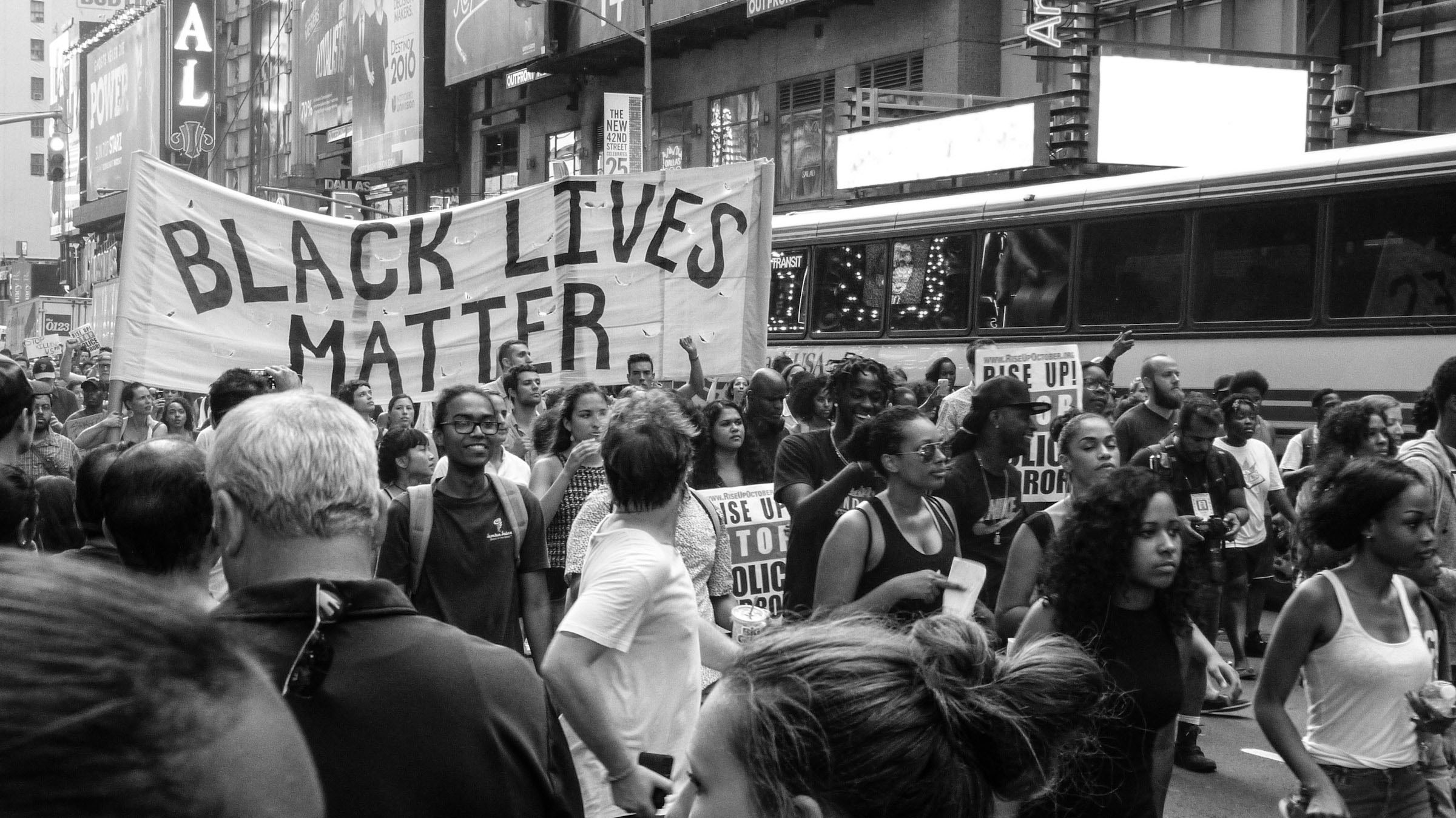 At a protest, youths hold up a banner that reads Black Lives Matter